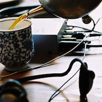 pouring tea near headphones, shallow DOF